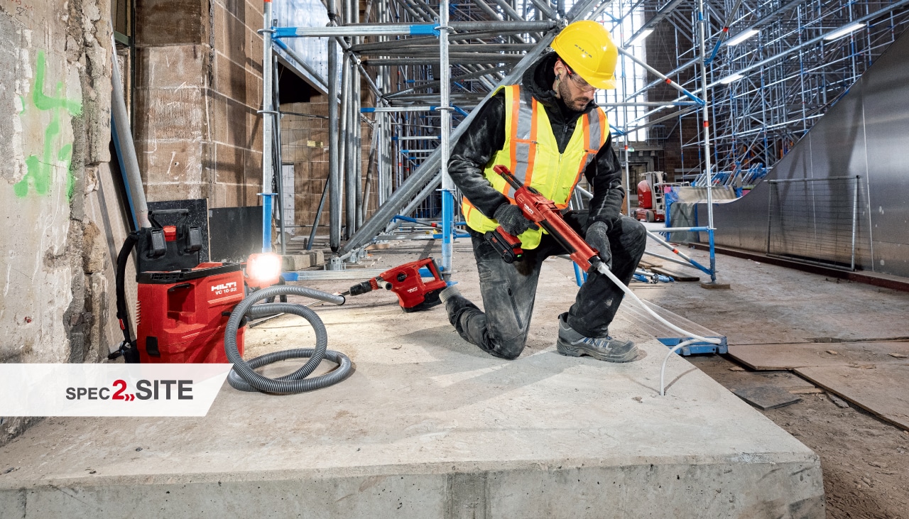 A contractor installs an anchor into concrete